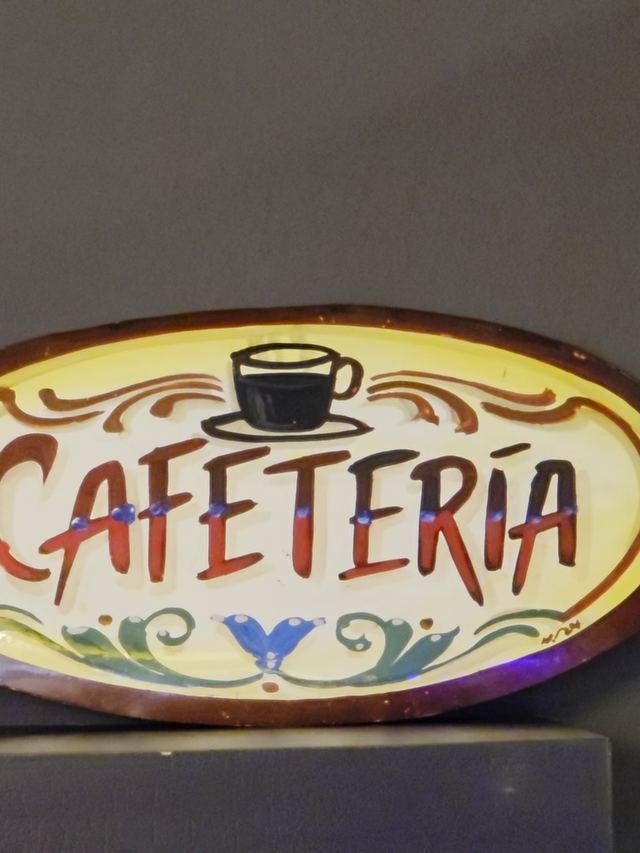 El cartel pintado de la cafetería con los vasos apilados