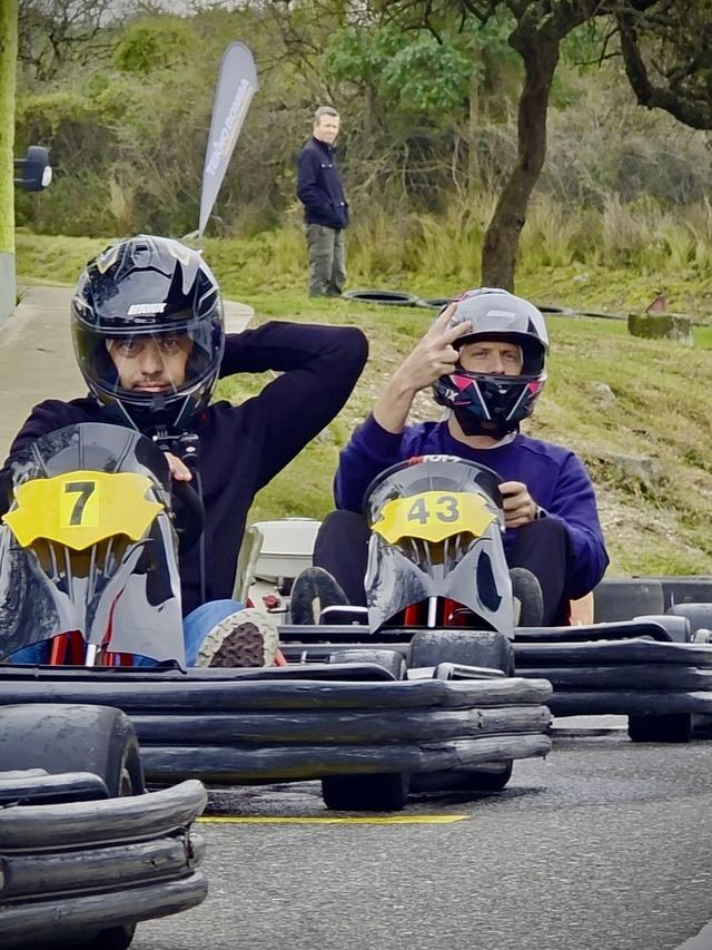 Dos pilotos con casco listos en la grilla, con los números 7 y 43