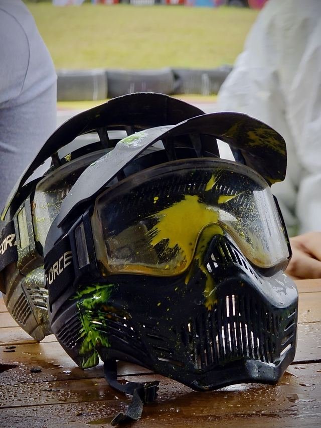 Máscara de paintball manchada de pintura sobre la mesa