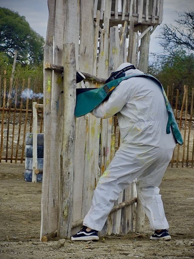 Jugador con máscara y equipo blanco cubriéndose detrás de una empalizada