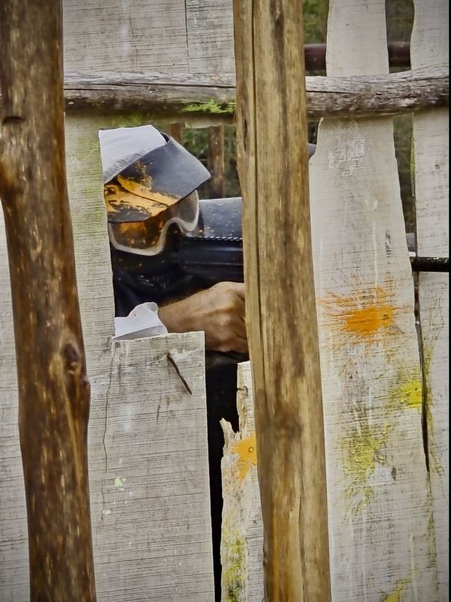 Marcadora asomando por el hueco de una barricada de madera