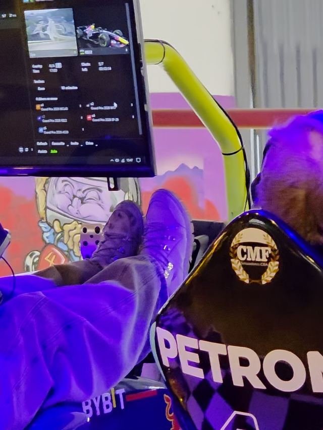 Un piloto de espaldas con auriculares en la butaca del simulador, con la pantalla adelante